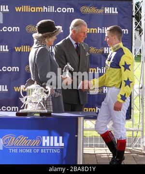 Der Prince of Wales und die Duchess of Cornwall präsentieren dem Jockey Connor Nichol eine Trophäe, nachdem er Osteopathisches Remedy zum Sieg im William Hill gefahren ist, der Dumfries House Ayrshire Handicap unterstützt Stockfoto