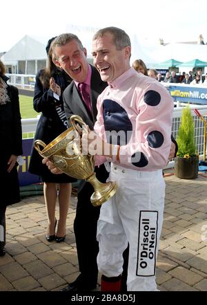 Jockey Pat Smullen (rechts) feiert mit der Trophäe und Trainer Kevin Ryan, nachdem Kapitän Ramius den William Hill Ayr Cold Cup gewonnen hat Stockfoto