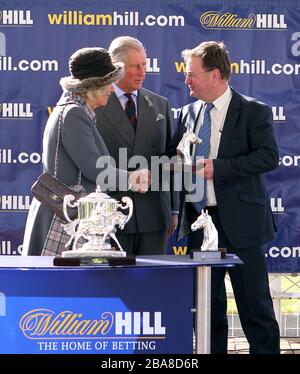 Trainer Michael Dods erhält vom Prince of Wales und der Duchess of Cornwall eine Trophäe, nachdem Osteopathisches Remedy den William Hill mit Unterstützung von Dumfries House Ayrshire Handicap gewonnen hat Stockfoto