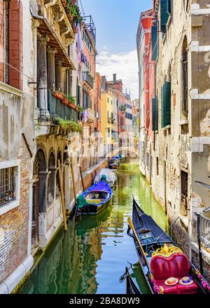 Venedig, Venetien, Italien 24. Juli 2017 Blick auf einen Nebenkanal mit Gondel und Booten entlang von Seitenhäusern Stockfoto