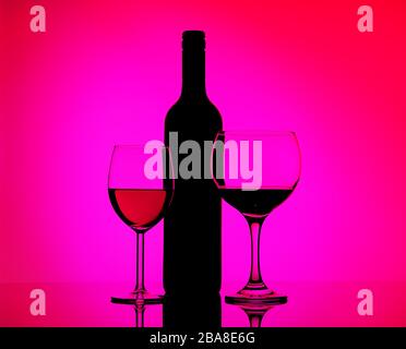 Zwei gefüllte Gläser mit Rotwein und Sherry, schwarze Silhouette der Flasche auf einem gespiegelten Hintergrund in seitlicher pinker und violetter Beleuchtung. Konzeptverkauf, Disc Stockfoto