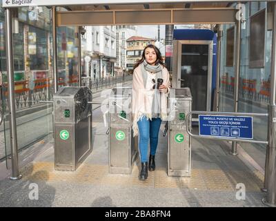 Schönes junges Mädchen bezahlt mit metrocard den Pendlerpreis und betritt das Drehkreuz im Transitsystem in Istanbul, Türkei.Traveler Woman Lifestyle Concep Stockfoto