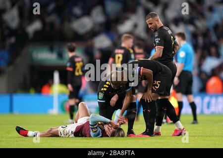 Jack Grealish von Aston Villa ist niedergeschlagen und wird von Spielern von Manchester City getröstet Stockfoto