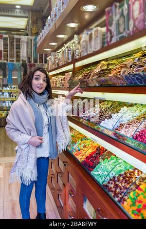 Schöne Reisende Frau schaut auf traditionelle türkische Desserts verkauft ein Geschäft in Istanbul, Türkei.Traveler Woman Lifestyle-Konzept. Stockfoto