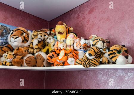 Tiger Soft Toy Kollektion auf einem Eckregal orange braun und gelb mit schwarzen Streifen in verschiedenen Größen und Formen. Süßes und kuscheliges Wildkatzendesign. Stockfoto