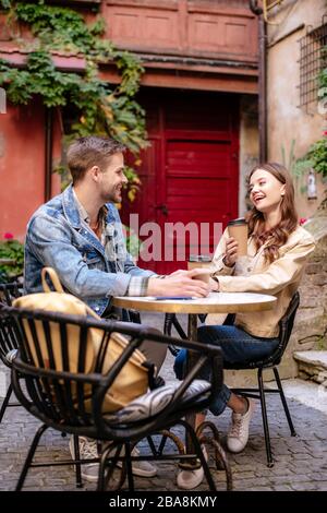 Selektive Fokussierung eines Paares mit Kaffeetassen, die sich im Café in Lemberg gegenseitig betrachten Stockfoto