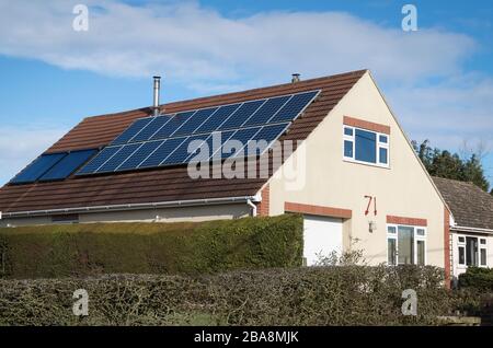 Eine Reihe von Solar-Heizplatten auf dem nach Süden gerichteten Dach eines Chalet-Bungalows in Bromham Wiltshire England UK Stockfoto