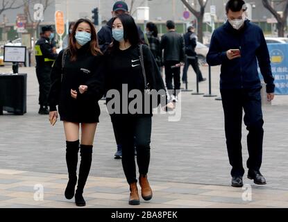 Peking, China. März 2020. Chinesen tragen immer noch schützende Gesichtsmasken, während sie in der Innenstadt spazieren, da die Bedrohung durch das tödliche Coronavirus (Covid-19) am Donnerstag, 26. März 2020 in Peking verblasst. Chinas Hauptstadt kehrt langsam in den Normalzustand zurück, während die Zahl der neuen Coronavirus-Fälle und die Rückkehr des Frühlingswetters stark gefallen sind. Foto von Stephen Shaver/UPI Credit: UPI/Alamy Live News Stockfoto