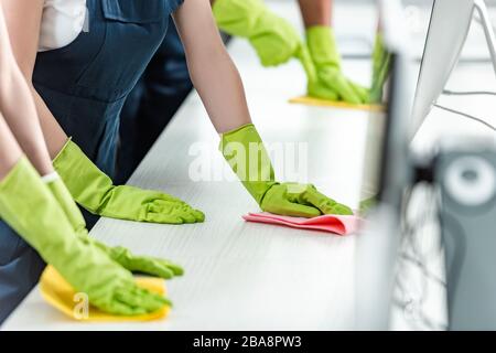 3/4-Ansicht der Reiniger in Gummihandschuhen Reinigungsbüro Schreibtisch Stockfoto