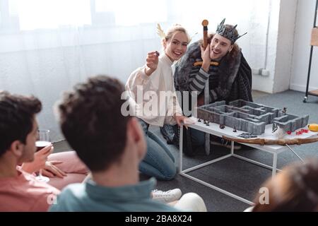 KIEW, UKRAINE - 27. JANUAR 2020: Selektiver Fokus von Mann und Frau in Feenkostümen Labyrinthspiel in der Nähe von Freunden Stockfoto