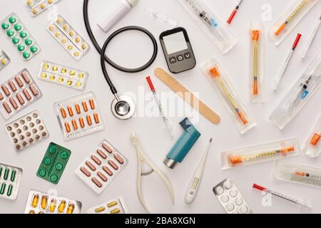 Draufsicht über Pillen, Spritzen und medizinische Gegenstände auf weißem Hintergrund Stockfoto