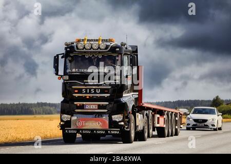 Schwarzer personalisierte Sisu Polar Tieflader Truck Trailer Teraskone Oy mit Geschwindigkeit auf der Straße unter dramatischem Himmel. Luopajarvi, Finnland. August 2019. Stockfoto