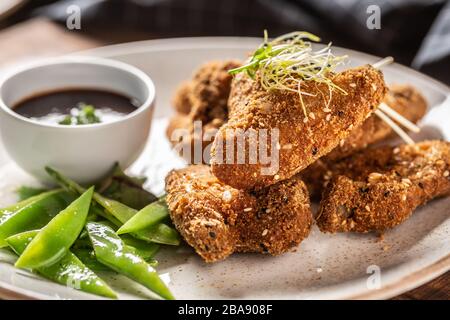 Gebratene Hühnerflügel mit Zuckererbsen und Kräutern Stockfoto