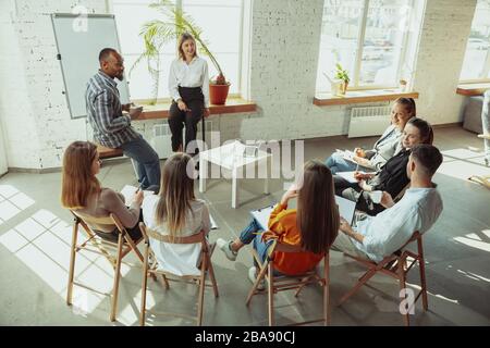 Live-Briefing. Referentin, die in der Halle in der Werkstatt vorspricht. Business Center. Rückansicht der Teilnehmer im Publikum. Konferenzveranstaltung, Schulung. Bildung, Vielfalt, integratives Konzept. Stockfoto