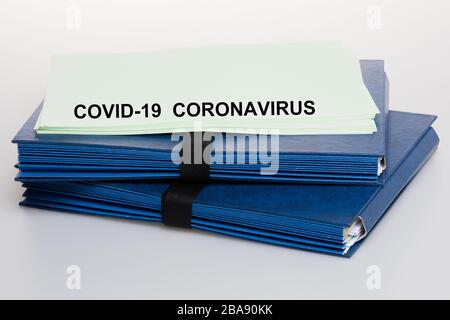 Coronavirus auf blauem Ordner mit einem Business Paperwork Covid-19 geschrieben Stockfoto