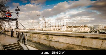 Blick auf die Londoner Straße auf die Westminster U-Bahn-Station Victoria Embankment mit dem London Eye im Hintergrund Stockfoto