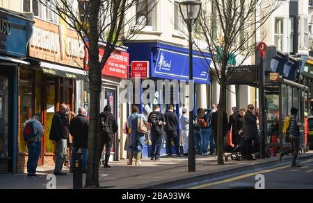 Brighton UK 26. März 2020 - Käufer warten auf dem Weg zu einem Morrisons Supermarkt in Brighton am Tag drei der Regierungen sperren Beschränkungen während der Coronavirus COVID-19-Pandemie-Krise. Kredit: Simon Dack / Alamy Live News Stockfoto