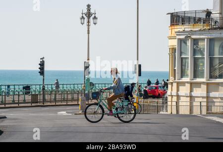 Brighton UK 26. März 2020 - EIN Radfahrer auf fast leeren Straßen an der Küste von Brighton am Tag drei der Regierungen sperren Beschränkungen während der Coronavirus COVID-19-Pandemie-Krise. Kredit: Simon Dack / Alamy Live News Stockfoto