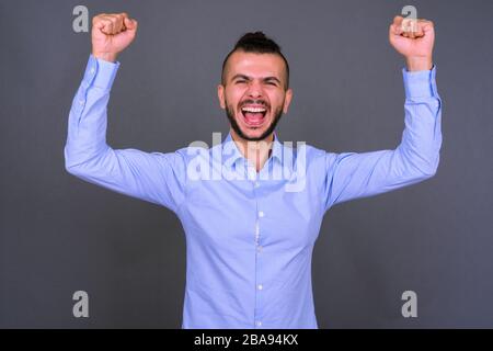 Portrait des fröhlichen bärtigen türkischen Kaufmanns, der gute Nachrichten erhält Stockfoto