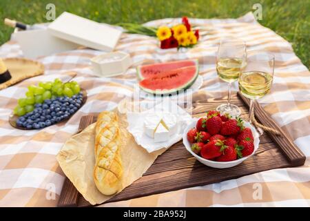 Romantisches Picknick in der Natur. Die Schönheit der untergehenden Sonne, frisches Obst und Wein. Stockfoto
