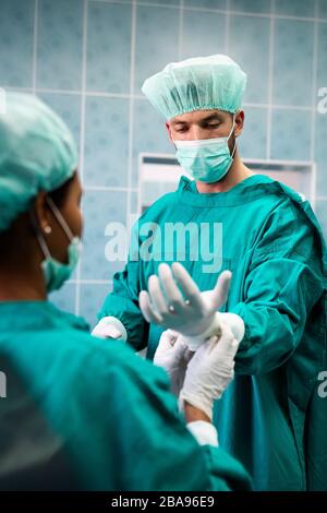 Team von Chirurgen im Operationssaal, die sich auf die Operation vorbereiten Stockfoto