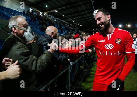 Ein Ebbsfleet Fan, der eine Schutzmaske trägt, feiert den Sieg gegen den FC Halifax Town mit Spieler Alex Lawless während des Premier-League-Spiels der Vanarama Conference im Shay Stockfoto