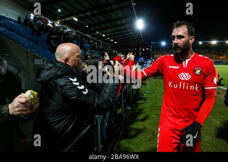 Ein Ebbsfleet Fan, der eine Schutzmaske trägt, feiert den Sieg gegen den FC Halifax Town mit Spieler Alex Lawless während des Premier-League-Spiels der Vanarama Conference im Shay Stockfoto