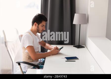 Junger Mann, der einen Rückenband trägt. Lendenwirbelstütze, Rückenstütze für Rückentrauma oder Muskelrückenstamm. Stockfoto