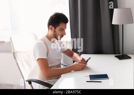 Junger Mann, der einen Rückenband trägt. Lendenwirbelstütze, Rückenstütze für Rückentrauma oder Muskelrückenstamm. Stockfoto