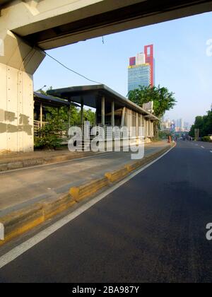 Eine leere Straße, Werbetafel und ein Busbahnhof neben einer Brücke in Jakarta, Indonesien. Stockfoto