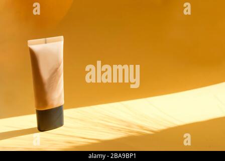 Flasche Kosmetik auf gelbem Hintergrund. Platz für Text. Harte Schatten Stockfoto