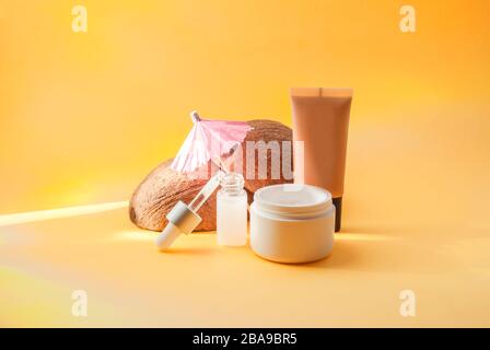 Set mit sommerlichen Kosmetikartikeln auf gelbem Hintergrund, harten Schatten. Warten auf Text. Stockfoto