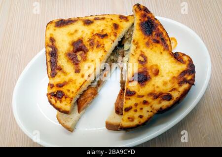 Schlichter Snack geröstete Wurst und Zwiebel-Sandwich in Weißbrot mit gegrilltem Käse obenauf Stockfoto