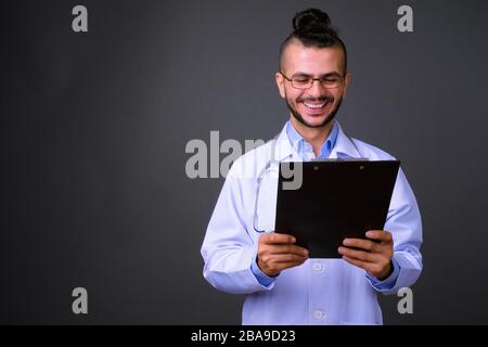 Portrait des fröhlichen bärtigen türkischen Mannes Doktor, der in der Zwischenablage liest Stockfoto