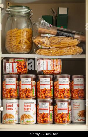 Ein Schrank voller bestockter Bohnen und Pasta. Stockfoto