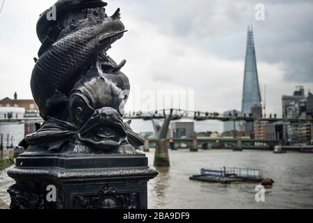 Verzierter Lampenpfosten mit Fischdesign aus Gusseisen und Shard und Millennium Bridge im Hintergrund, London, Großbritannien Stockfoto