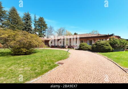 Grüner Garten und schönes Haus an einem sonnigen Frühlingstag Stockfoto