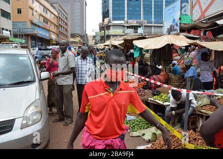 Kampala, Uganda. März 2020. Ein Mann, der eine Maske trägt, läuft am Nakasero-Markt in Kampala, Uganda, am 26. März 2020 vorbei. Der ugandische Präsident Yoweri Museveni kündigte am Mittwoch eine 14-tägige Suspendierung des öffentlichen Verkehrs als eine der Maßnahmen an, mit denen die Verbreitung des neuartigen Coronavirus (COVID-19) im ostafrikanischen Land gestoppt werden soll. Credit: Nicholas Kajoba/Xinhua/Alamy Live News Stockfoto