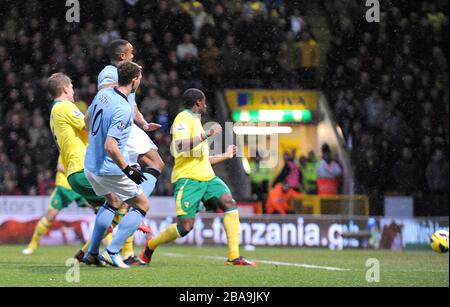 Der Manchester-City-Edin Dzeko (links) schießt, um das zweite Tor seiner Mannschaft zu erzielen Stockfoto