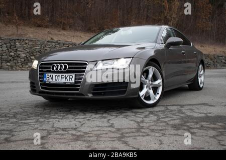 Luxuryous deutscher Sportwagen - Audi A7 isoliert auf einem Parkplatz, Kunstfotos aus verschiedenen Winkeln, braune Metallic-Farbe, Spoiler offen Stockfoto