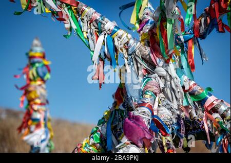 Heilige Säulen mit Band auf Kap Burhan von Olkhon Island. Buryat-Traditionen. Schamanistische und buddische Riten des Baikalsee. Insel Olkhon, Baika Stockfoto