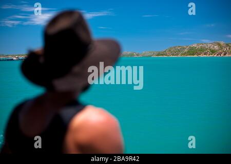 Ein Mann in trägt ein ikonisches Symbol der australischen Kultur, denkt nachdenklich, während er zwischen Inseln in Westaustralien reist. Stockfoto