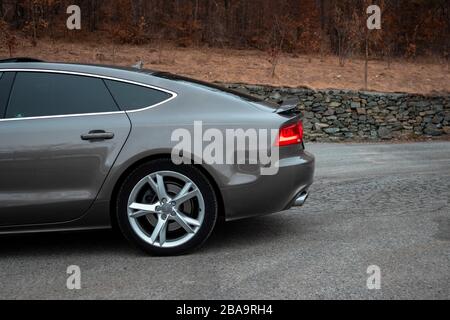 Luxuryous deutscher Sportwagen - Audi A7 isoliert auf einem Parkplatz, Kunstfotos aus verschiedenen Winkeln, braune Metallic-Farbe, Spoiler offen Stockfoto