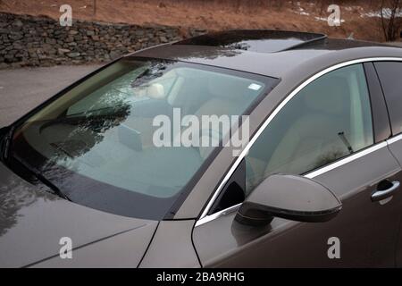 Luxuryous deutscher Sportwagen - Audi A7 isoliert auf einem Parkplatz, Kunstfotos aus verschiedenen Winkeln, braune Metallic-Farbe, Spoiler offen Stockfoto