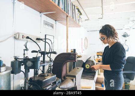 Weitwinkel von Frauen arbeiten mit präzisem Werkzeug, um ein kleines Produkt zu machen Stockfoto