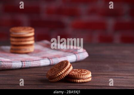 Sandwich-Kekse, Cream-Kekse, Plätzchen mit Creme-Füllung auf Holztisch Stockfoto