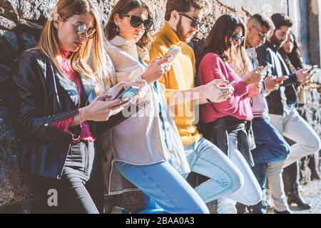 Tausendjährige Generation von Menschen, die Smartphones nutzen. Junge Menschen, die vom Konzept der Abhängigkeit von sozialen Netzwerken süchtig sind. Freunde, die Handys ag verwenden Stockfoto