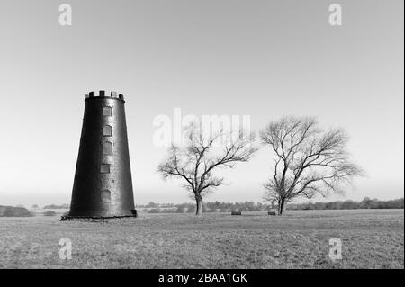 Black Mill, ein lokales Wahrzeichen, das von grünen Bäumen unter hellem Himmel im Westwood im frühen Frühjahr in der Nähe von Beverley, Yorkshire, Großbritannien, flankiert wird. Stockfoto