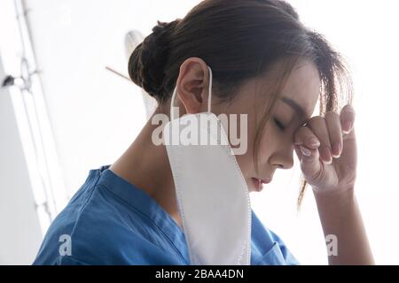 Erschöpfter weiblicher Arzt reibt Ihre Augen Stockfoto