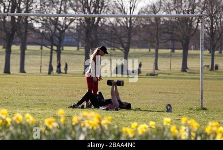 Leicester, Leicestershire, Großbritannien. März 2020. Eine Paarübung unter einem Torpfosten im Victoria Park in Leicester während der Coronavirus Pandemie. Credit Darren Staples/Alamy Live News. Stockfoto